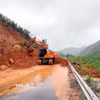 Lực lượng chức năng thu dọn đất đá sạt lở. (Ảnh: Phạm Lợi/TTXVN)