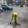 Công nhân công ty thoát nước vớt rác để tiêu thoát nước nhanh. (Ảnh: Nguyễn Thắng/TTXVN)