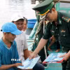Cấp phát tài liệu chống khai thác IUU cho ngư dân. (Ảnh: Hồng Hiếu/TTXVN)