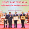 Ông Nguyễn Xuân Thắng trao Bằng công nhận đạt chuẩn mức độ 1 cho Ban Giám hiệu nhà trường. (Ảnh: Trung Kiên/TTXVN)