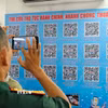 Người dân sử dụng mã QR để tra cứu thông tin thủ tục hành chính tại điểm hỗ trợ chuyển đổi số cộng đồng. (Ảnh: Trung Nguyên/TTXVN)