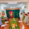 Cơ quan cảnh sát điều tra tống đạt các quyết định tố tụng đối với Trần Mỹ Tiên (áo carô). (Ảnh: TTXVN phát)