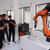 Thử nghiệm robot công nghiệp tại Trung tâm Đào tạo, Nghiên cứu và Phát triển Ứng dụng Robot Công nghiệp và Trí tuệ nhân tạo (trường Đại học Bách khoa-Đại học Đà Nẵng). (Ảnh: Khoa Chương/TTXVN)