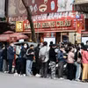 Người dân xếp hàng dài chờ mua vàng tại cửa hàng Bảo Tín Minh Châu trên phố Trần Nhân Tông, Hà Nội, dù có thông báo tạm hết hàng. (Ảnh: Trần Việt/TTXVN)