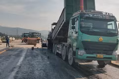 Nhà thầu thi công thảm nhựa nền đường một dự án đường bộ. (Ảnh: Việt Hùng/Vietnam+)