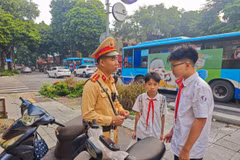 Lực lượng Cảnh sát giao thông Hà Nội xử lý và tuyên truyền kiến thức về an toàn giao thông cho học sinh chưa đủ tuổi điều khiển xe máy. (Ảnh: PV/Vietnam+)