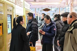 Khách hàng chờ bán đồ trang sức bằng vàng tại một máy bán vàng tự động đặt trong một trung tâm mua sắm ở Thượng Hải. (Ảnh: AFP)