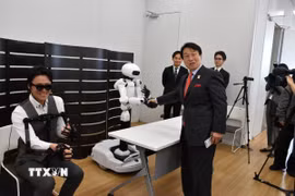 Robot từ xa hoạt động đồng bộ với chuyển động của robot chính trong động tác bắt tay với Tổng giám đốc điều hành Tập đoàn Pasona. (Ảnh: Nguyễn Tuyến/TTXVN)
