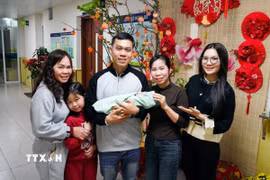 Niềm hạnh phúc của cả gia đình vợ chồng anh Nguyễn Văn Hùng và chị Vũ Thảo Phương khi được đón thành viên mới. (Ảnh: Khánh Hòa/TTXVN)
