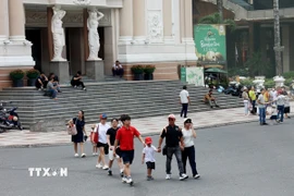Du khách dạo chơi ở Quảng trường Lam Sơn, trước Nhà hát Thành phố Hồ Chí Minh. (Ảnh: Hồng Đạt/TTXVN)