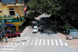 Nhiều phương tiện tham gia giao thông đỗ vào nơi có bóng mát trên đường Nguyễn Ngọc Vũ để dừng đèn đỏ. (Ảnh: Lê Đông/TTXVN)