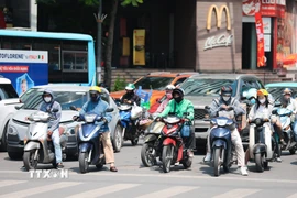 Khẩu trang, áo chống nắng là những thứ không thể thiếu cảu người dân ở Hà Nội khi tham gia giao thông trong những ngày nắng nóng. (Ảnh: Lê Đông/TTXVN)
