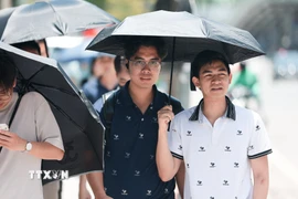 Ô là công cụ hữu hiệu nhất để tránh nắng của người đi bộ. (Ảnh: Lê Đông/TTXVN)
