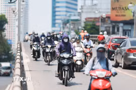 Khẩu trang, áo chống nắng là những thứ không thể thiếu của người dân khi tham gia giao thông trong những ngày nắng nóng. (Ảnh: Lê Đông/TTXVN)