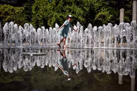 Em nhỏ chơi đùa bên đài phun nước để tránh nóng tại Budapest, Hungary. (Ảnh: THX/TTXVN phát)