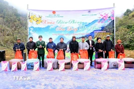 Tặng quà cho nhân dân tại Chương trình “Xuân Biên phòng, ấm lòng dân bản” ở xã biên giới Lóng Phiêng. (Ảnh: Quang Quyết/TTXVN)