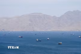 Tàu thuyền di chuyển trên eo biển Hormuz, ngoài khơi tỉnh Musandam, Oman, ngày 27/4/2026. (Ảnh: Reuters/TTXVN)