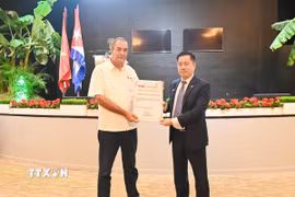 Bộ trưởng Ydael Pérez Brito trao Bằng khen cho tập thể các chuyên gia kỹ sư Việt Nam và Viện Khoa học nông nghiệp Việt Nam bởi những đóng góp to lớn cho hợp tác sản xuất lúa gạo Việt Nam-Cuba. (Ảnh: Việt Hùn/TTXVN)