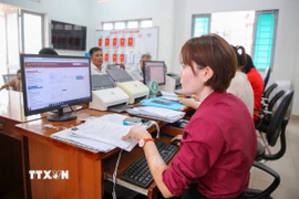 Cán bộ Trung tâm phục vụ Hành chính công xã Tân Đông thực hiện quy trình giải quyết thủ tục hành chính trên các hệ thống phần mềm. (Ảnh: Giang Phương/TTXVN)