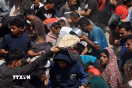 Người dân nhận thực phẩm cứu trợ tại Gaza. (Ảnh: THX/TTXVN)