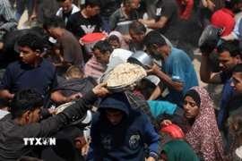 Người dân nhận thực phẩm cứu trợ tại Gaza. (Ảnh: THX/TTXVN)