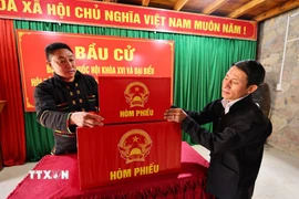 Sắp xếp hòm phiếu, trang trí hội trường, dán danh sách bầu cử tại nhà văn hóa thôn Lô Lô Chải, xã Lũng Cú, tỉnh Tuyên Quang. (Ảnh: Minh Đức/TTXVN)