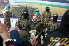 Lữ đoàn Al-Qassam, một cánh quân của Phong trào Hamas, trao trả con tin Israel cho Uỷ ban Chữ thập đỏ quốc tế tại trại tị nạn Nuseirat ở miền Trung Dải Gaza, ngày 22/2/2025. (Ảnh: THX/TTXVN)