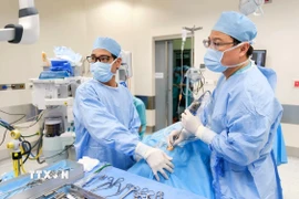 Các bác sỹ Bệnh viện FV tiến hành phẫu thuật dẫn lưu ápxe và nạo sạch ổ nhiễm trùng cho bệnh nhi. (Ảnh: TTXVN phát)