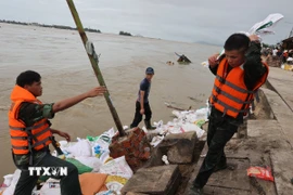 Hàng trăm cán bộ, chiến sĩ Sư đoàn 315 (Quân khu 5) cùng hân dân chạy đua cùng thời gian, gia cố bờ kè khu vực bị sạt lở. (Ảnh: Anh Dũng/TTXVN)