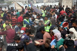 Người dân Palestine nhận thức ăn cứu trợ tại thành phố Gaza ngày 2/5/2025. (Ảnh: THX/TTXVN)