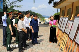 Các đại biểu tham quan triển lãm ảnh. (Ảnh: Phan Quân/TTXVN)