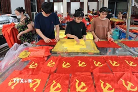 Từng công đoạn, từng lá cờ được người dân nơi đây thực hiện một cách tỉ mỉ. (Ảnh: Lê Đông/TTXVN)