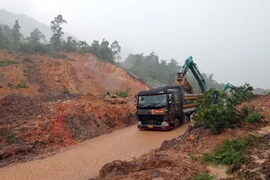 Hiện các lực lượng chức năng đã tổ chức phân luồng giao thông từ xa, cấm các phương tiện lưu thông trên tuyến đường này, đồng thời huy động nhân lực và phương tiện khẩn trương khắc phục để sớm thông tuyến trở lại. (Ảnh: Đỗ Trưởng/TTXVN)