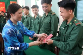 Bà Nguyễn Thị Hoàn Xuân, Phó Bí thư Thường trực Đảng ủy - Chủ tịch HĐND phường Rạch Giá lì xì cho chiến sĩ Đồn Biên phòng cửa khẩu Giang Thành. (Ảnh: Lê Huy Hải/TTXVN)