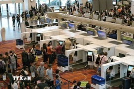 Hành khách xếp hàng tại quầy làm thủ tục ở sân bay Changi, Singapore. (Ảnh: THX/TTXVN)