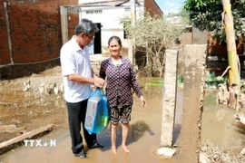 Phó Chủ tịch Ủy ban Nhân dân tỉnh Lâm Đồng Nguyễn Minh tặng quà, động viên người dân bị thiệt hại do ngập lụt tại xã Bắc Bình. (Ảnh: Nguyễn Thanh/TTXVN)