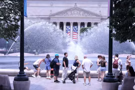 Du khách tránh nắng nóng bên đài phun nước tại khu vực National Mall (Quảng trường Quốc gia) ở thủ đô Washington D.C. (Ảnh: Ngọc Quang/TTXVN)