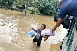Thanh niên dùng xe ben đi phát cơm, tiếp tế người dân Hàm Thắng. (Ảnh: Hồng Hiếu/TTXVN)