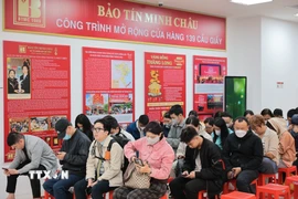 Người dân xếp hàng trật tự theo lượt chờ đến lượt giao dịch trong ngày vía Thần Tài tại cửa hàng vàng trên phố Cầu Giấy. (Ảnh: Lê Đông/TTXVN)