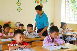 Thầy Phan Ngọc Khánh, giáo viên Điểm trường Tiểu học bản Na Ngân (thuộc Trường Phổ thông dân tộc bán trú Tiểu học Nga My, tỉnh Nghệ An) trong giờ lên lớp. (Ảnh: Xuân Tiến/TTXVN)