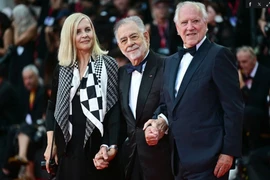 Đạo diễn người Mỹ Francis Ford Coppola (giữa) cùng đạo diễn Đức Werner Herzo (phải), nghệ sỹ mỹ thuật Lena Herzog (trái) chụp ảnh trên thảm đỏ. (Ảnh: AFP)