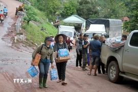 Người dân vùng lũ xã biên giới Mỹ Lý (Nghệ An) nhận hàng cứu trợ. (Ảnh: Văn Tý/TTXVN)