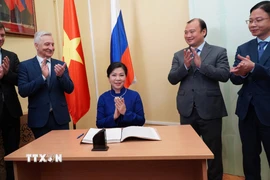 Phu nhân Ngô Phương Ly ghi sổ cảm tưởng tại Trung tâm Văn hóa Nga-Việt. (Ảnh: Tâm Hằng/TTXVN)