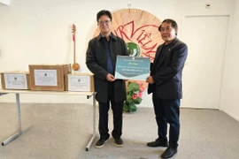 Ông Phạm Văn Thắng trao tặng sách cho đại diện Trung tâm văn hóa Việt Nam tại Pháp.