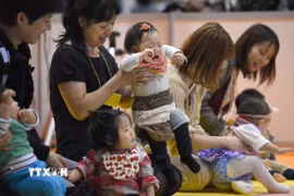 Các em bé tham gia cuộc thi bò tại Nhật Bản. (Ảnh: AFP/TTXVN)