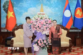 Tổng Giám đốc Thông tấn xã Việt Nam Vũ Việt Trang tặng lẵng hoa chúc mừng Đại sứ Lào tại Việt Nam Khamphao Ernthavanh nhân dịp kỷ niệm 50 năm Quốc khánh nước CHDCND Lào. (Ảnh: Hoàng Hiếu/TTXVN)