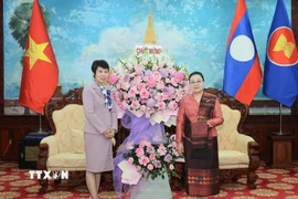 Tổng Giám đốc Thông tấn xã Việt Nam Vũ Việt Trang tặng lẵng hoa chúc mừng Đại sứ Lào tại Việt Nam Khamphao Ernthavanh nhân dịp kỷ niệm 50 năm Quốc khánh nước CHDCND Lào. (Ảnh: Hoàng Hiếu/TTXVN)