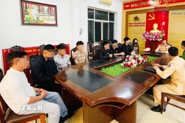 Nhóm thanh thiếu niên bị triệu tập làm việc tại cơ quan chức năng. (Ảnh: TTXVN phát)