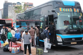 Hành khách lên xe tại Bến xe Giáp Bát. (Ảnh: Hoàng Hiếu/TTXVN)