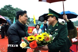 Lãnh đạo Biên phòng Hoành Mô (Quảng Ninh) tặng hoa chúc mừng các du khách nhập cảnh. (Ảnh: TTXVN phát)